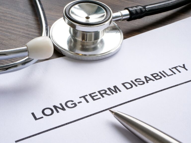 A long term disability form next to a pen and stethoscope.